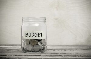 glass jar with the word budget on it filled with money and change